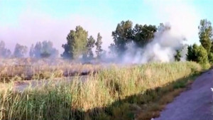 Smoke rises at site where a rocket, shot from Syria, landed in an open field in the Galilee.